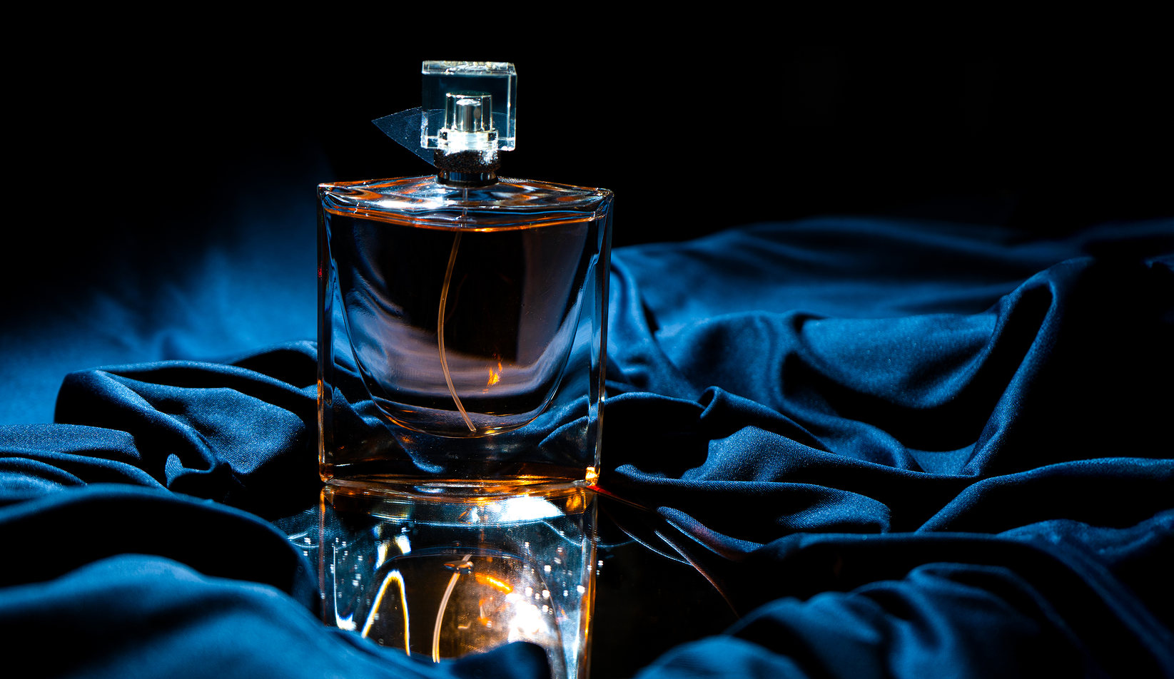 Perfume sobre tela azul